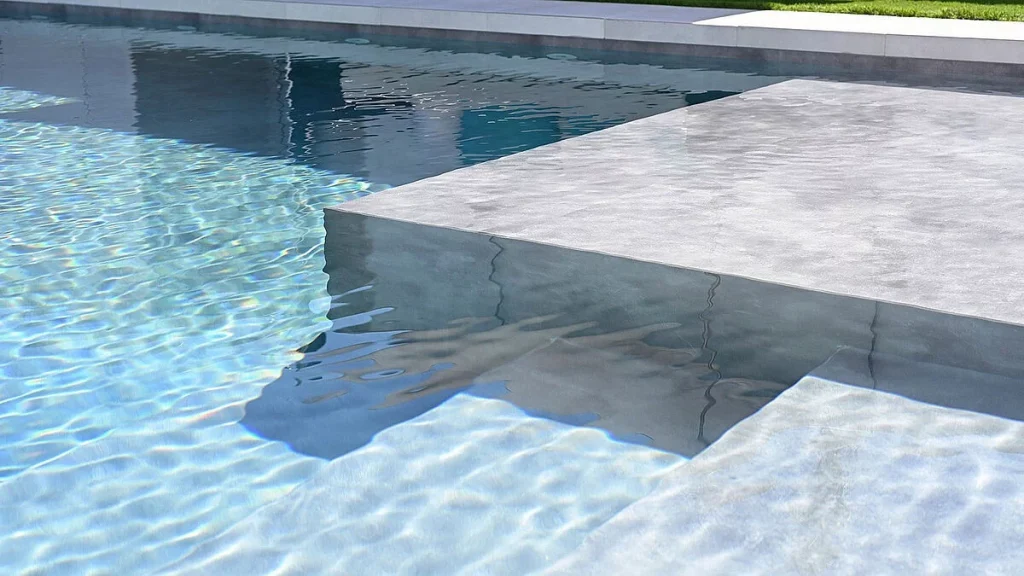 Piscina con membrana URBAN, donde el color y el brillo del agua se mezclan con los tonos grises intensos y profundos.