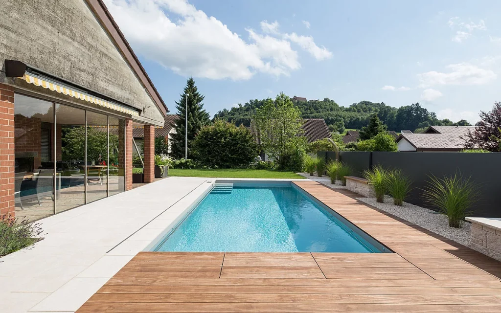 Piscina con membrana armada gris claro en patio interior, fusionando estilo y funcionalidad.