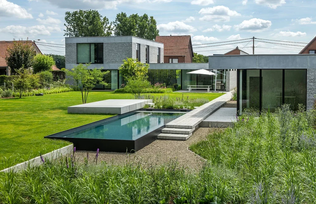 Piscina elegante y moderna en un jardín de colores verdes y vivos.