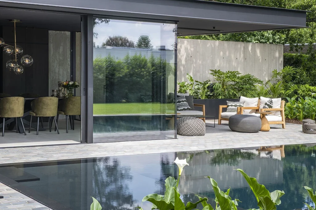 Una piscina elegante en la que se puede apreciar el reflejo de la casa.